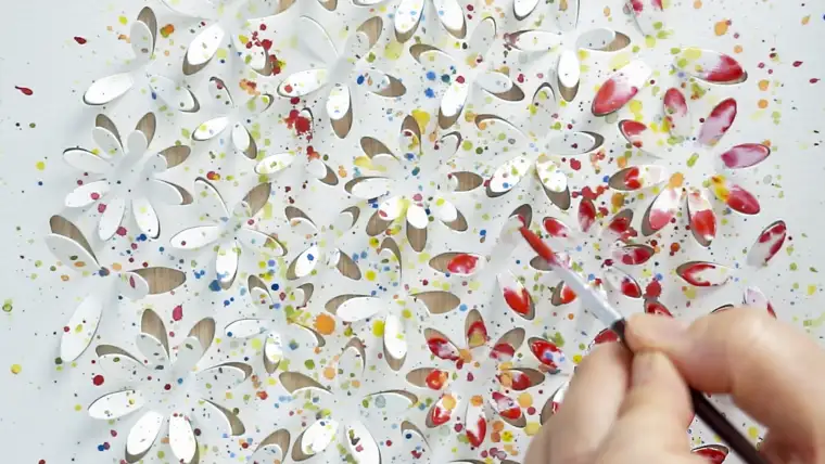 Watercolor being added to raised 3D paper details in an Atelier Aisha DIY art kit.