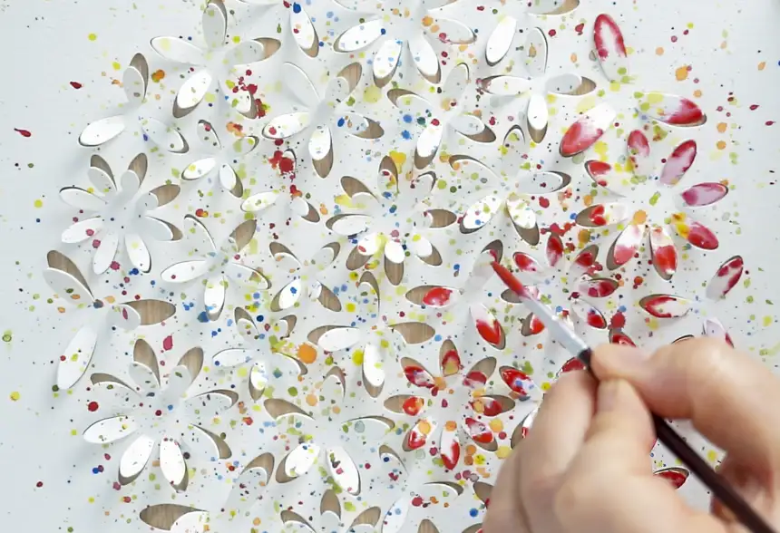 Watercolor being added to raised 3D paper details in an Atelier Aisha DIY art kit.