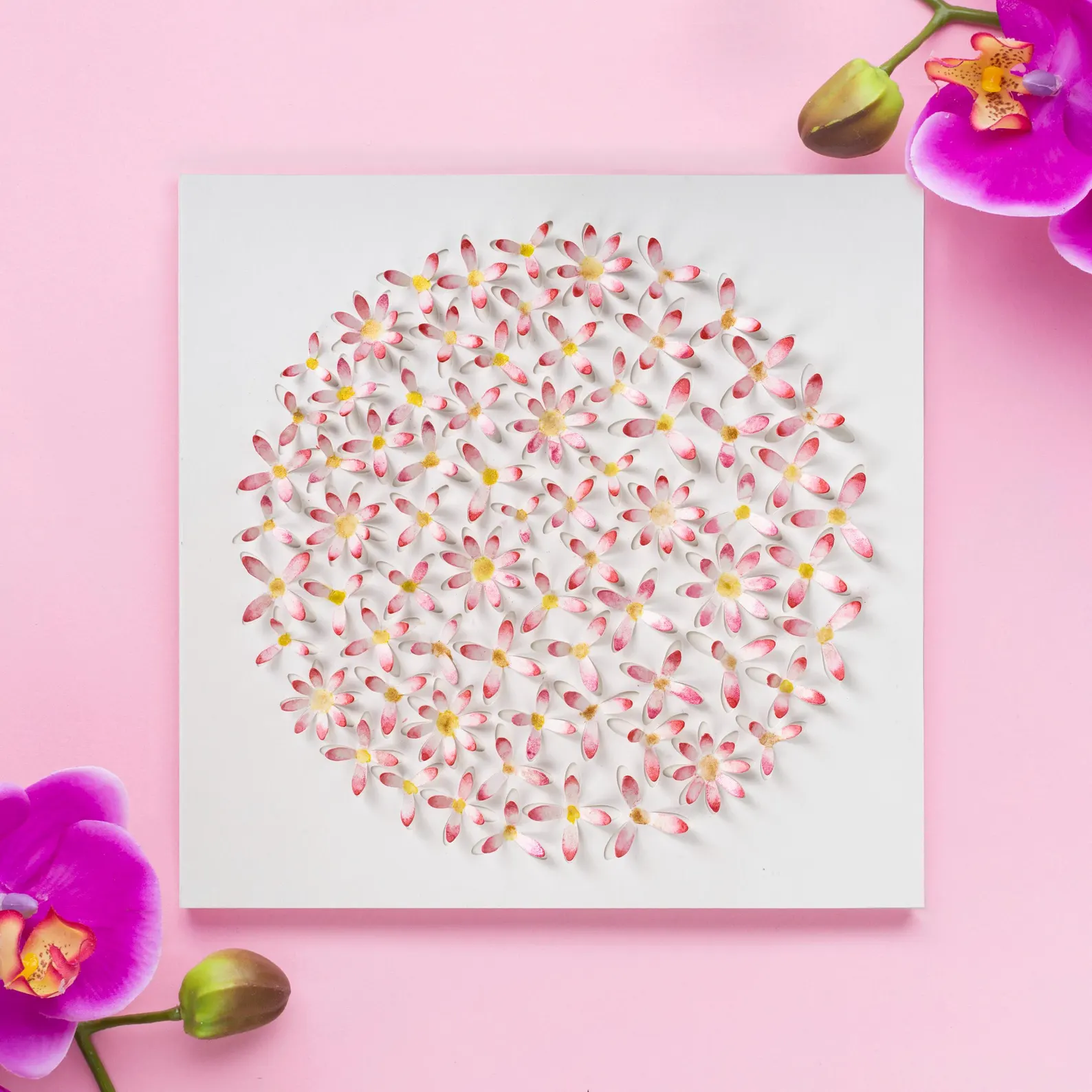 Pink daisy circle 3D watercolor wall art in a light wood frame styled with eucalyptus leaves